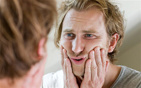 BHGAFK Man looking in mirror and touching face