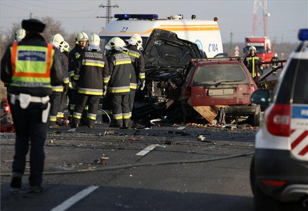 Rendőr helyszínel és tűzoltók végzik a műszaki mentést két összeroncsolódott jármű közelében, melyek frontálisan ütköztek a 4-es főút 164-es kilométerénél, Karcag külterületén 2013. január 6-án. A balesetben a vétlen, magyar rendszámú szamélyautó öt utasa közül négy felnőtt: három férfi és egy nő a helyszínen életét vesztette, míg egy csecsemő, akit életveszélyes állapotban, mentőhelikopterrel szállítottak kórházba a debreceni Kenézy Kórházban halt meg. A balesetet  okozó francia rendszámú gépkocsi három utasa sértetlenül úszta meg a karambolt. MTI Fotó: Bugány János