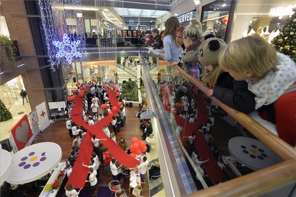 Az ország legnagyobb AIDS-szalagját feszítik ki a Magyar Ifjúsági Vöröskereszt aktivistái a szervezet HIV-AIDS-prevenciós versenyén a fővárosi Corvin Plázában 2014. december 1-jén