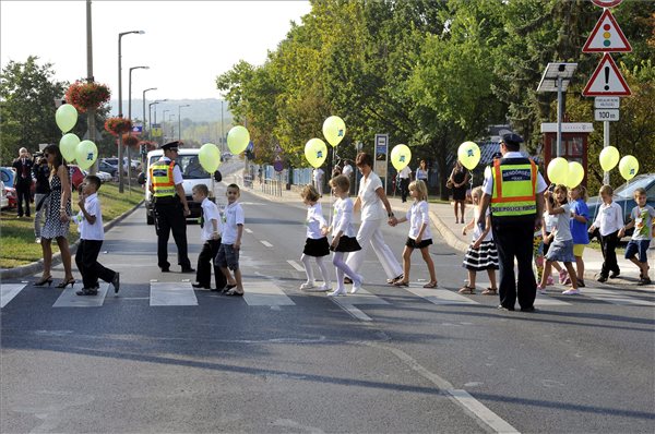 A budaörsi Herman Ottó Általános Iskola diákjai rendőri segítséggel mennek át a zebrán az iskola közelében 2012. szeptember 3-án. MTI Fotó: Kovács Attila