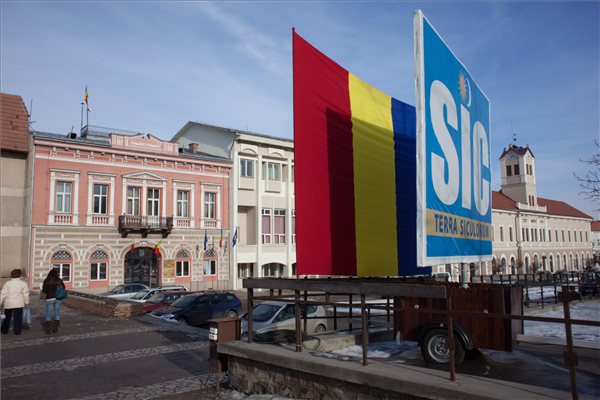 Román zászló takarja el a SIC/Terra Siculorum (Székelyföld) feliratú transzparenst Sepsiszentgyörgy belvárosában 2013. január 24-én. A zászlót a prefektúra helyeztette ki, mielőtt megemlékezést tartott délelőtt Moldva és Havasalföld egyesülésének 154. évfordulóján. A két fejedelemség egyesülése alapozta meg Románia 1861-ben történt megalakulását. A zászló első alkalommal december elsején, a román nemzeti ünnep alkalmából került a tábla elé. A latin nyelvű táblát a Romániai Magyar Demokrata Szövetség (RMDSZ) 2012. november 8-án tartott demonstrációján állították fel. MTI Fotó: Henning János